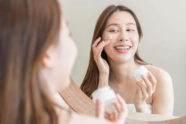 Photo of woman applying skin product to her face